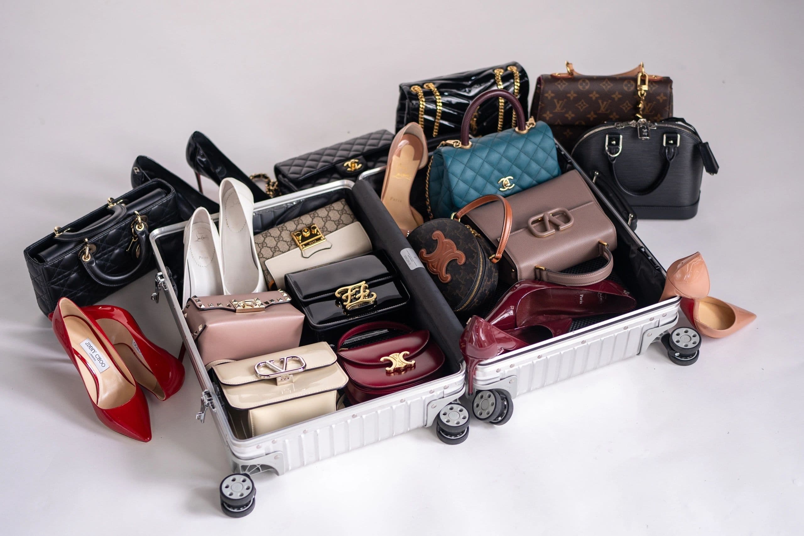Luxury handbags and shoes packed in an open suitcase